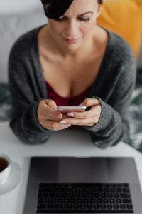Kaboompics - A brunette woman works with a laptop and a phone