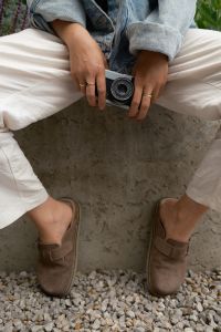 Kaboompics - Hands Holding A Vintage Camera While Sitting Outdoors