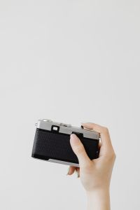 Kaboompics - Hand Adjusting the Top Plate of a Vintage Film Camera on White