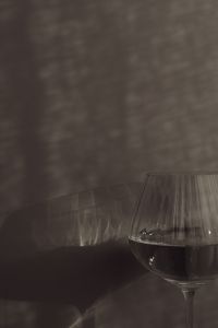 Kaboompics - Moody Dark Glass of Water Casting Shadows on a Neutral Wall