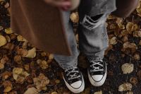 Kaboompics - Black Sneakers and Jeans Standing on Fallen Autumn Leaves