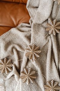 Kaboompics - Close Up of Wooden Snowflakes on Cozy Blanket