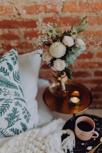 Kaboompics - Close-Up of White Floral Bouquet and Pink Coffee Cup beside a Brick Wall, Cozy Bedroom Bedside Styling