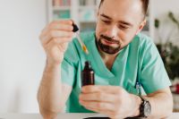 Kaboompics - Doctor Dispensing Liquid Into Amber Bottle
