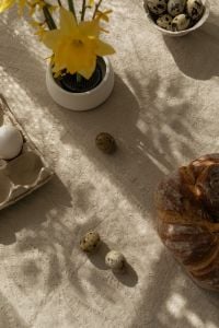 Kaboompics - Yellow Spring Flower, Quail Eggs and Easter Bread on a Neutral Linen Table