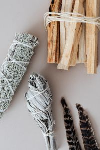 Kaboompics - Sage and Palo Santo Smudge Sticks with Feather for Energy Cleansing