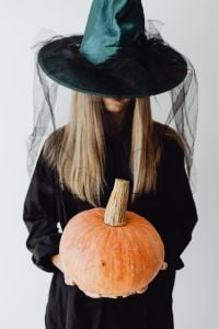Kaboompics - Woman in Witch Costume Holding an Orange Pumpkin Portrait