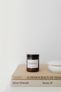Kaboompics - Amber Candle on Books with White Bowl and Minimal Copy Space