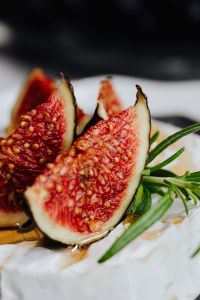 Kaboompics - Macro Fig Wedges and Rosemary on Camembert with Dark Background