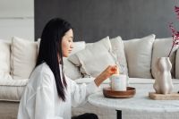 Kaboompics - Woman Lighting a Candle in Soft Interior Light