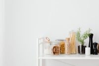 Kaboompics - Minimal Pantry Organization with Glass Food Jars and Copy Space on White Shelf