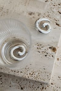 Kaboompics - Silver Spiral Earrings Beside a Glass