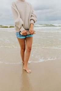 Kaboompics - Barefoot Woman Holding a Book While Walking Along the Waterline, Cloudy Beach Lifestyle