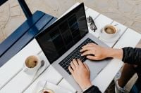 Kaboompics - Overhead Laptop Workspace with Coffee, Dessert and Sunglasses