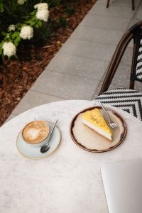 Kaboompics - Cappuccino and Cake on a Cafe Table by the Garden