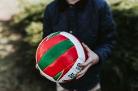 Kaboompics - Person Holding a Red and Green Volleyball Outdoors, Wider Sports Lifestyle Photo