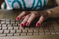 Kaboompics - Closeup of female hands typing text on a wireless wooden keyboard