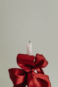 Kaboompics - Close-Up of White Candle with Large Red Satin Bow