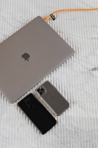 Kaboompics - Two Smartphones and Silver Laptop with Orange Charging Cable on White Marble