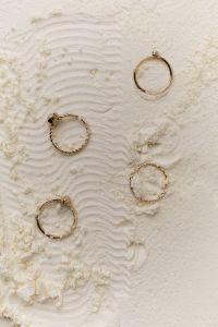 Kaboompics - Gold Rings on Wavy Flour Texture for Product Styling