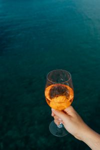 Kaboompics - Hand and Cocktail Glass Framed by Deep Blue Water