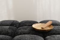 Kaboompics - Palo Santo in a Mother-of-Pearl Bowl on a Black Textured Sofa