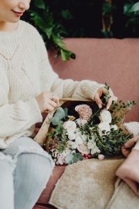 Kaboompics - Close-Up of a Woman Holding a Pink and White Bouquet at a Cafe
