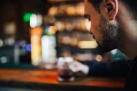 Kaboompics - Handsome young man having a whiskey in a pub