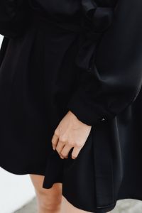 Kaboompics - Close-Up of Woman’s Hand on Black Satin Dress