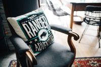 Kaboompics - Black Armchair with Graphic Pillow and Blue Rug