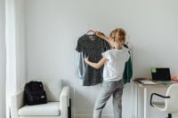 Kaboompics - Teen Girl Comparing a Black Floral Dress on a Hanger with Her Wardrobe, Bedroom Fashion