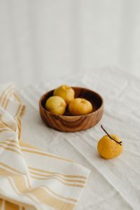 Kaboompics - Japanese Quince Bowl and Loose Fruit on Striped Linen, Vertical Chaenomeles Photography