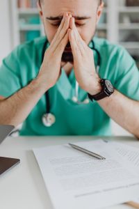 Kaboompics - Tired Doctor Pausing Over Medical Documents