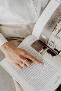 Kaboompics - Woman Pointing to Architectural Drawings and Text in an Open Design Book