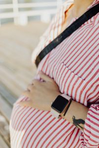 Kaboompics - Pregnant Belly and Smartwatch with Copy Space on Outdoor Deck
