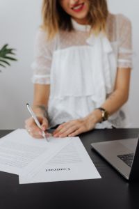 Kaboompics - Freelancer Signing a Contract Beside Laptop
