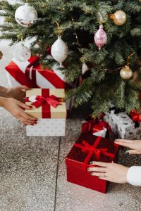 Kaboompics - Hands Placing Wrapped Gifts Under a Christmas Tree