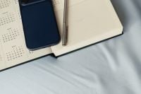 Kaboompics - Smartphone and Open Planner on Blue Bedding