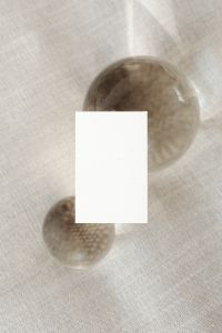 Kaboompics - Overhead Blank Business Card and Glass Orbs on Textured Linen