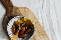 Kaboompics - Bowl of Acorns and Oak Leaves on a Wooden Board