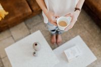 Kaboompics - A woman with a cup of coffee reads a book