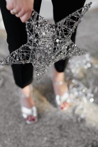 Kaboompics - Silver Christmas Star Held by Woman in Sparkling Party Outfit