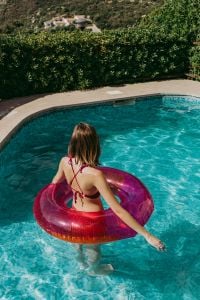 Kaboompics - A beautiful woman in a pool with an inflatable ring