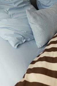 Kaboompics - Soft Blue Pillows and Striped Bedding in Cozy Bedroom