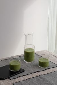 Kaboompics - Green Smoothie Glasses and Carafe on a Linen Tablecloth