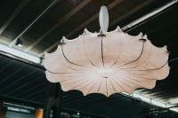 Kaboompics - Scalloped Sculptural Pendant Light against a Dark Industrial Exhibition Ceiling