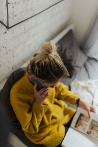 Kaboompics - Overhead View of Smartphone Call and Open Book in a Cozy Home
