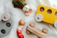Kaboompics - Wooden Toy Cars, Bead Caterpillar and Fabric Mouse on a Blanket
