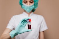 Kaboompics - Masked Healthcare Worker Holding Blood Test Vials, Wide Medical Education Portrait