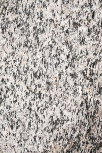Kaboompics - High-Contrast White and Charcoal Mineral Streaks Across a Vertical Coastal Rock Surface